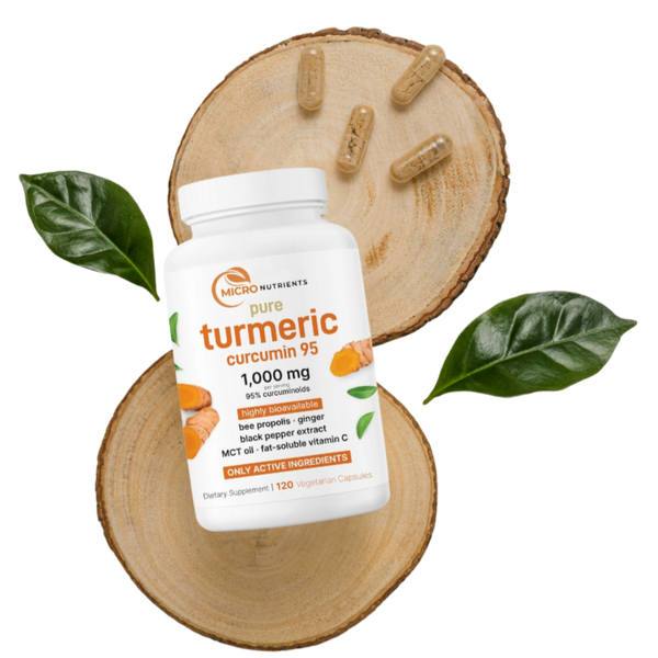 Turmeric supplement bottle with capsules on a wooden slice and leaves on a white background