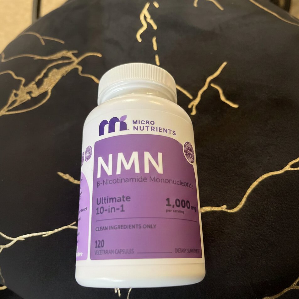 NMN supplement bottle with purple label on a dark background