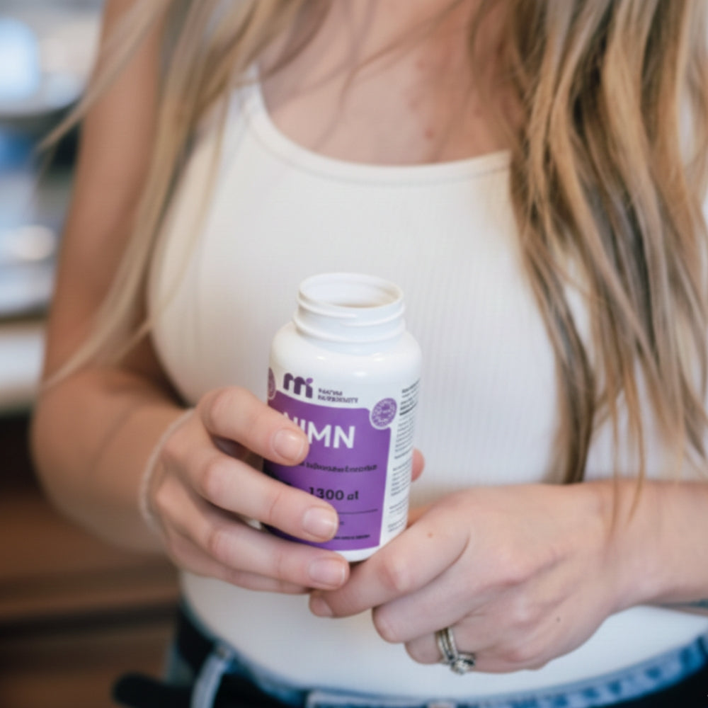 Person holding a bottle labeled 'nmn' with a purple label.