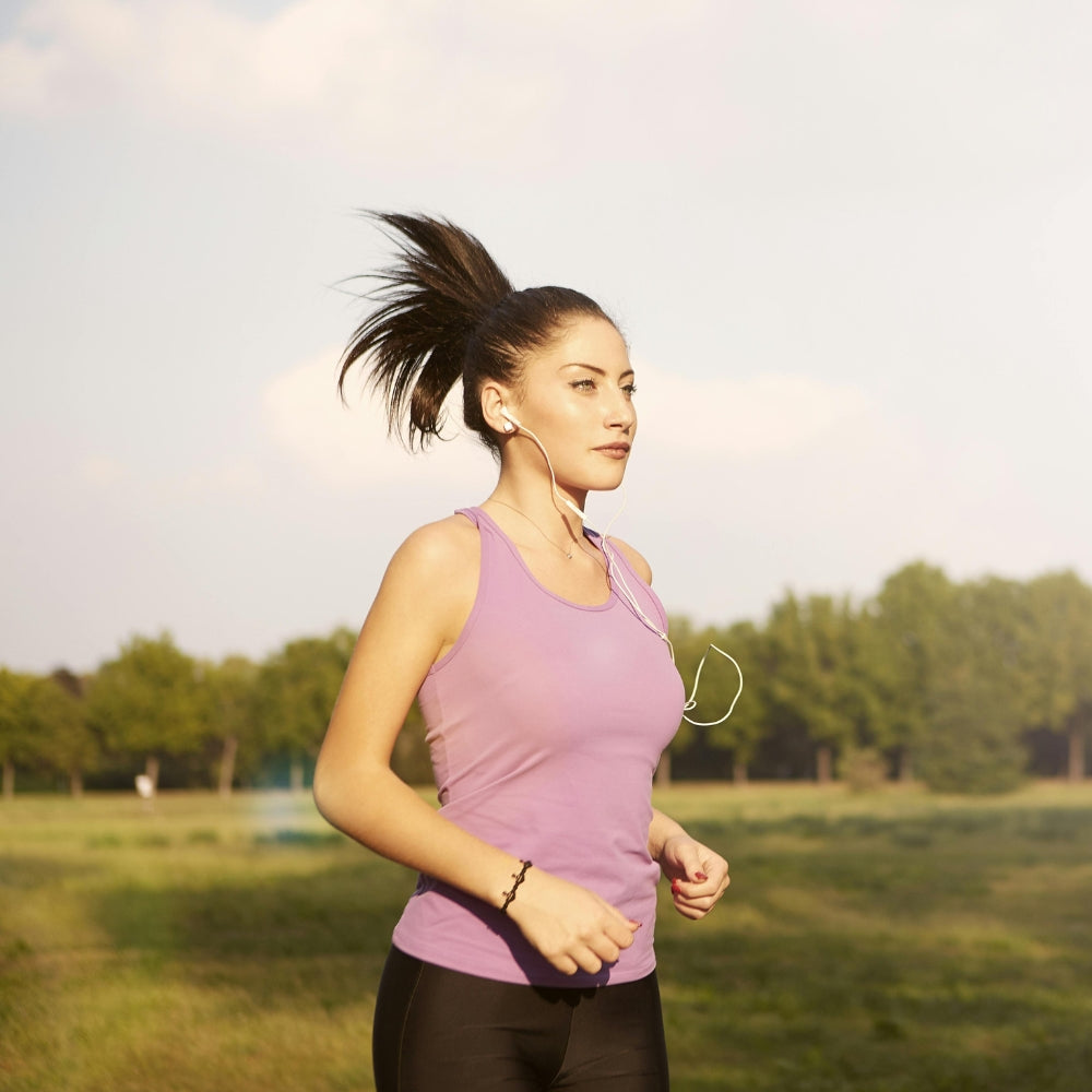 Woman running outdoors with trees in the background