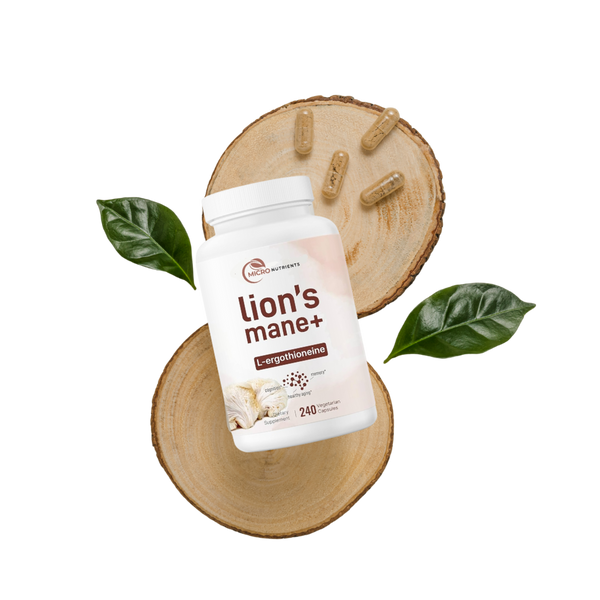 Lion's Mane+ supplement bottle on a wooden surface with capsules and leaves.