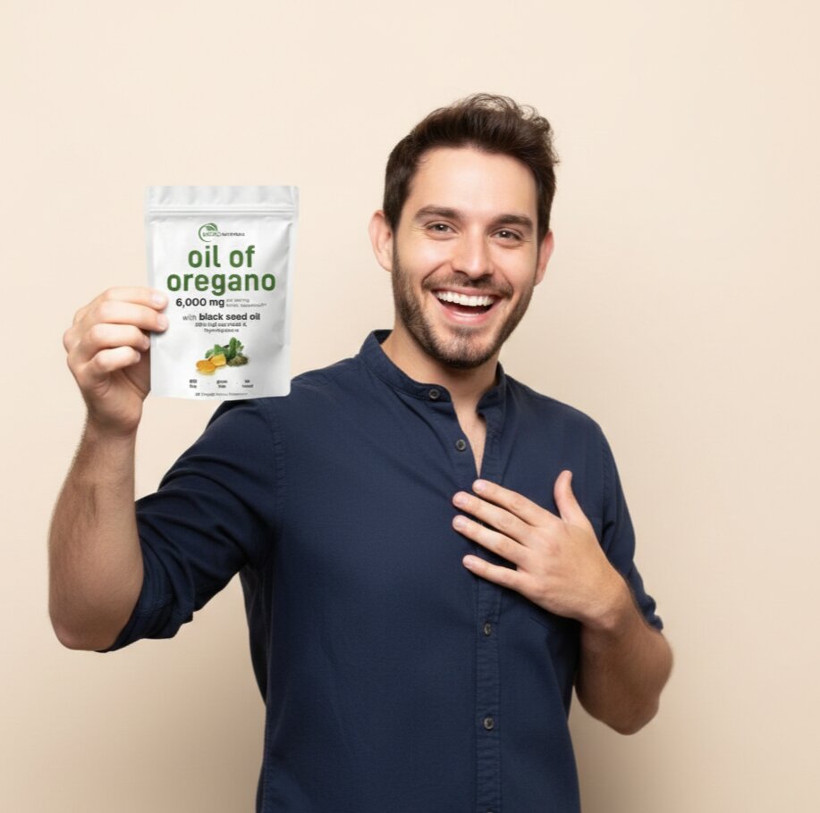 Man holding a package of 'oil of oregano' against a beige background