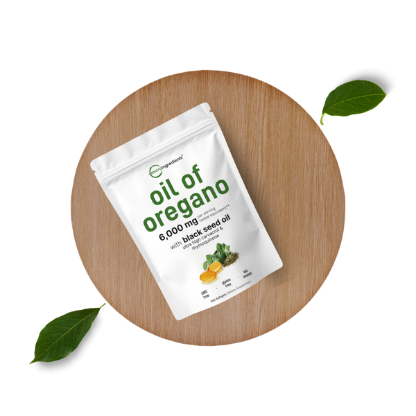 Package of 'oil of oregano' on a wooden surface with leaves around