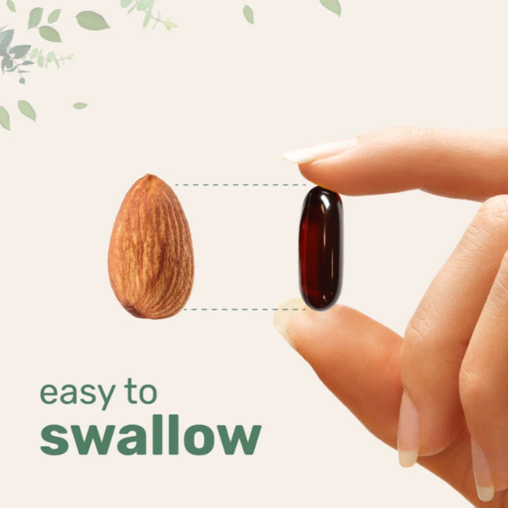 Hand holding a dark-colored pill next to an almond with text 'easy to swallow' on a light background.