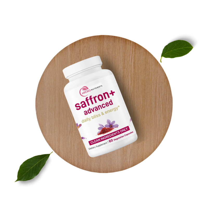 Saffron+ Advanced supplement bottle on a wooden surface with leaves.