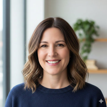 Woman with shoulder-length brown hair wearing a navy sweater indoors.